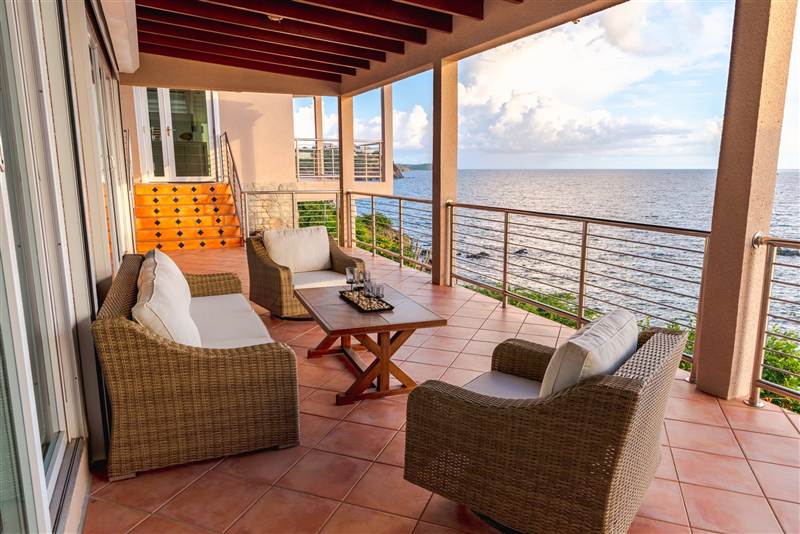 Outdoor lounge and patio with Caribbean Sea views at Ocean Pointe Caribe, St Thomas USVI