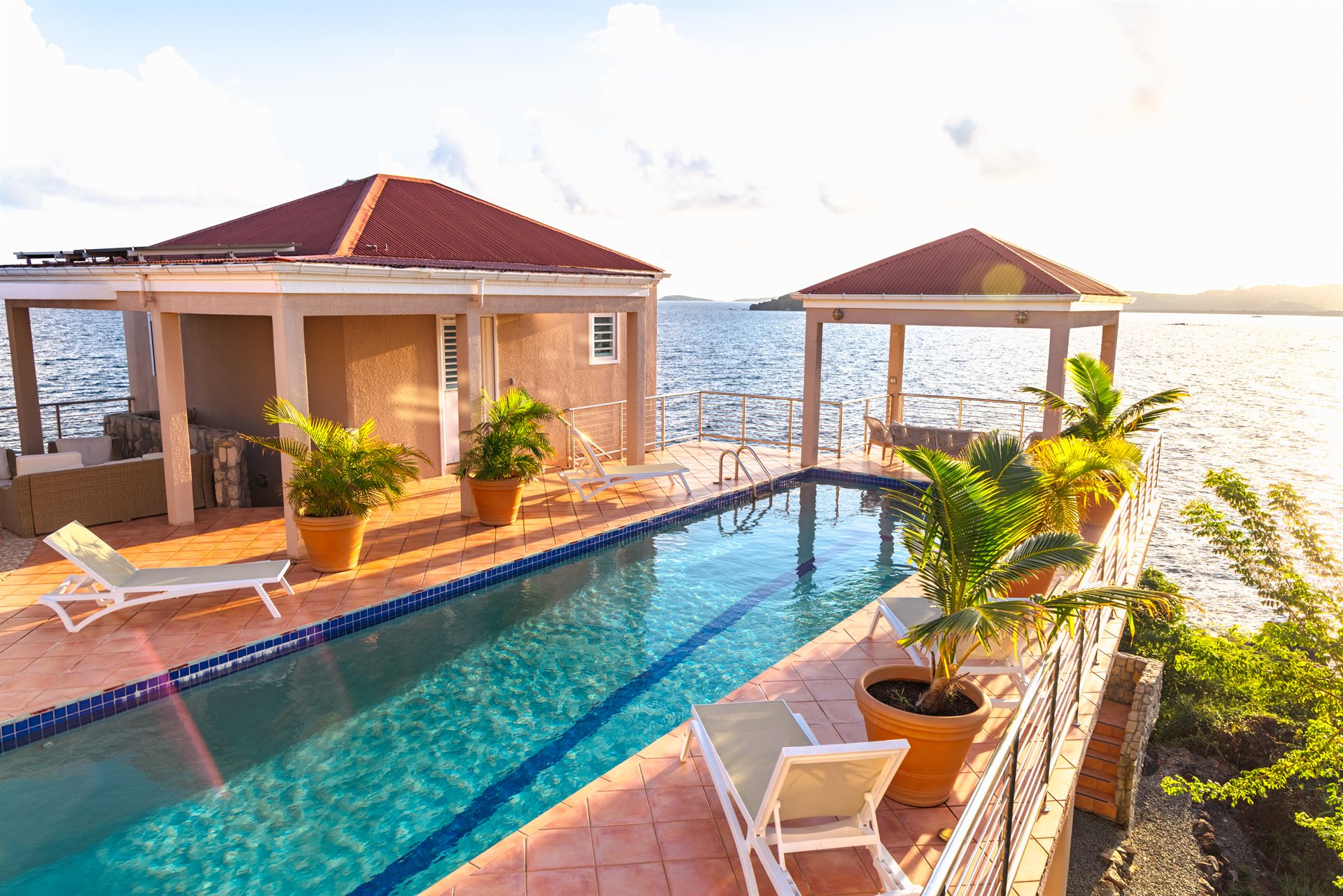 Golden sunset reflecting over the lap pool at Ocean Pointe Caribe estate, US Virgin Islands